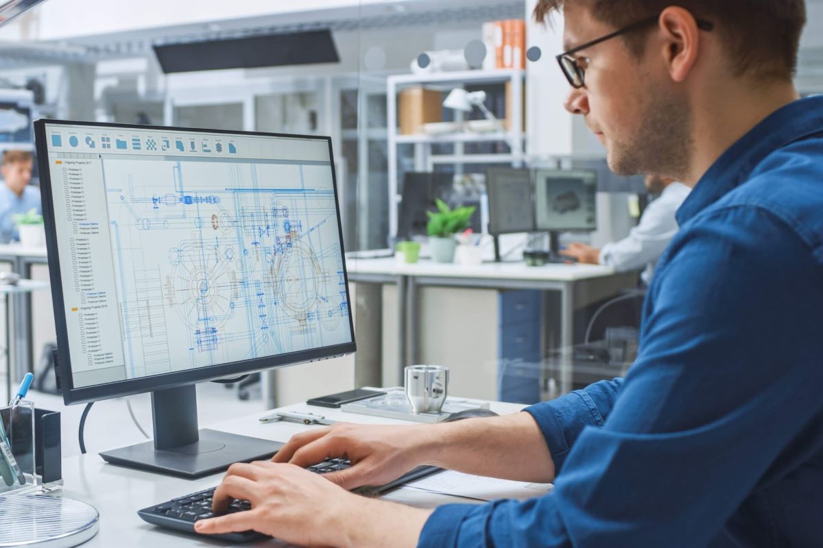 Man wearing a blue shirt working on a computer.