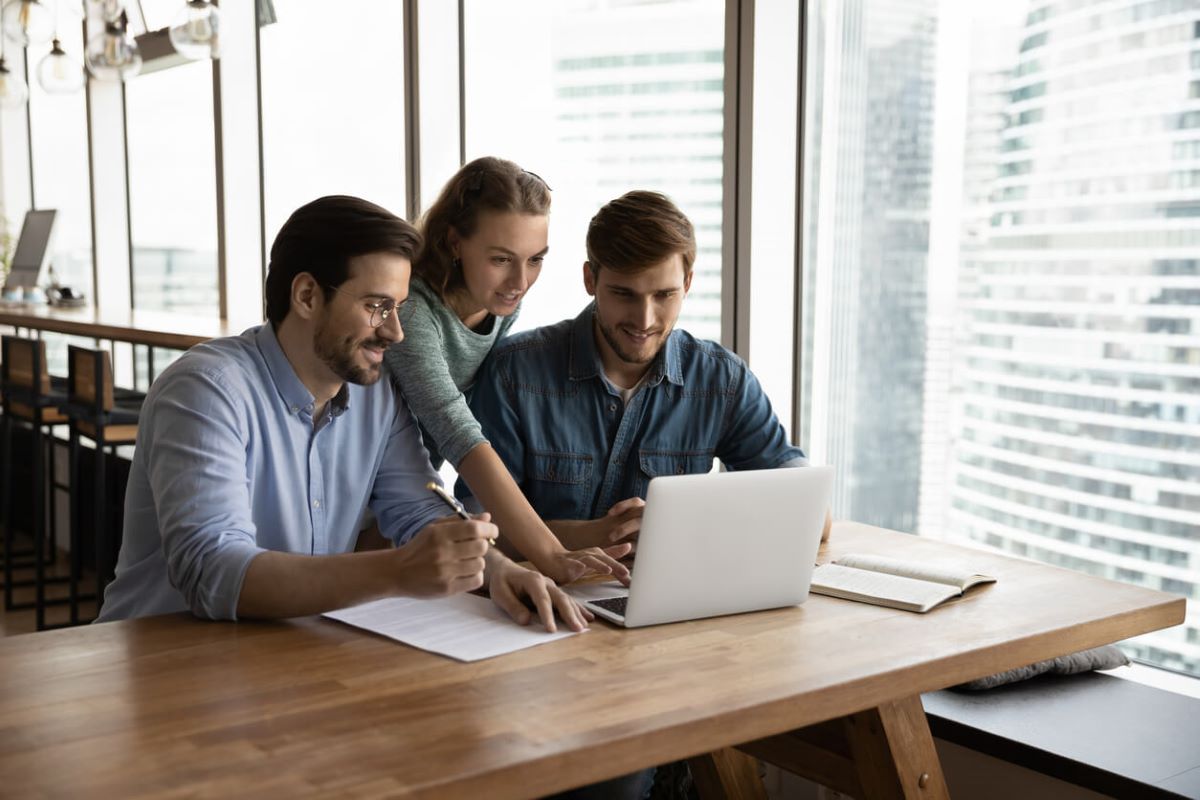 3 persons working together on one laptop